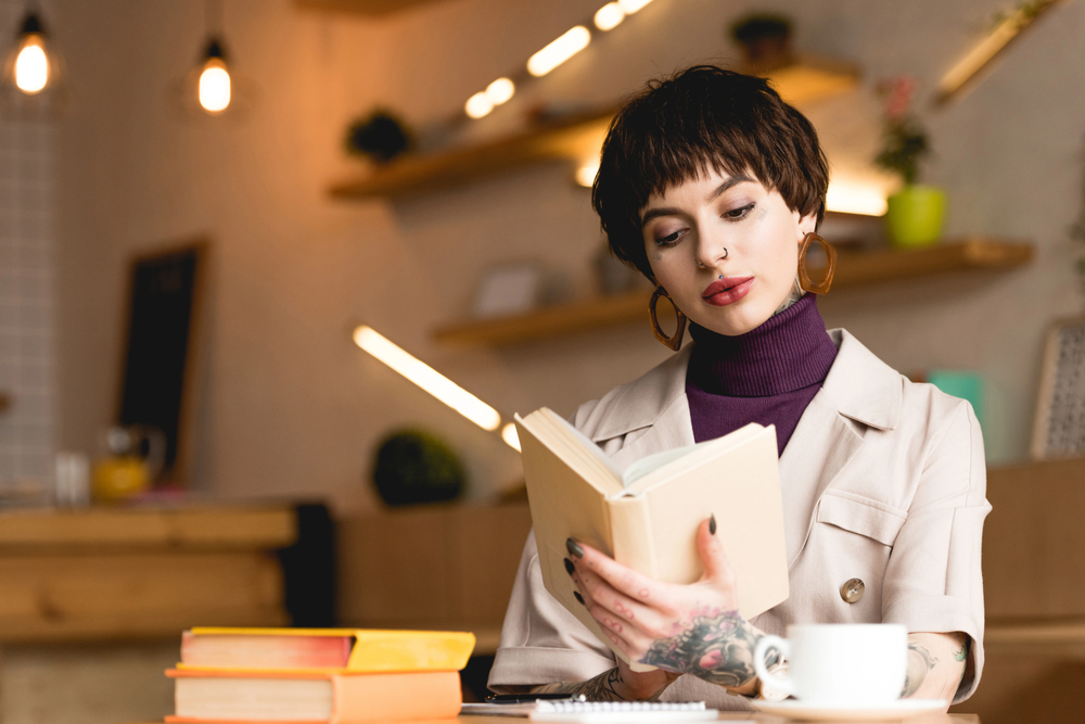 A woman reading a book sitting at a table